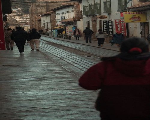 People walking calmly along a city sidewalk in Peru